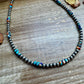 Turquoise & silver bead necklace (43D76281-4E19) on wood surface