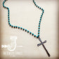 Turquoise beaded necklace with a cross pendant.