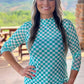 Woman wearing a teal and white checkered shirt.