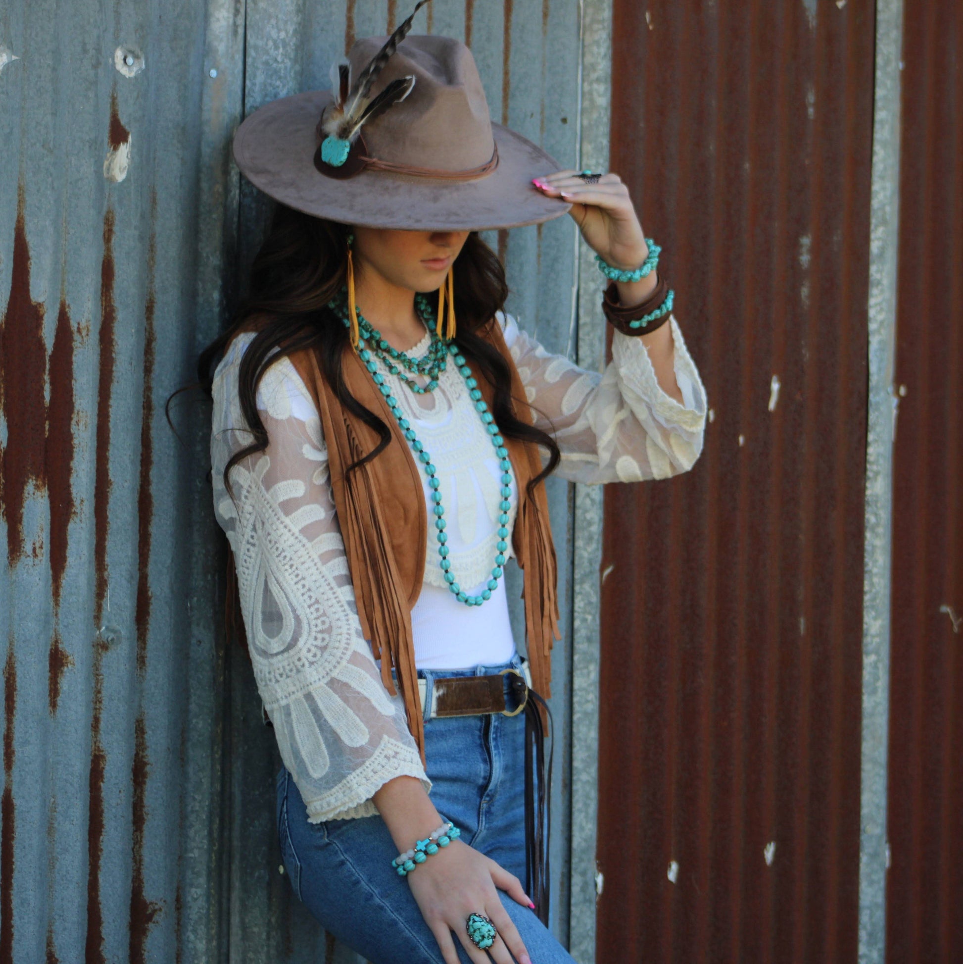 Woman in cowboy hat and jewelry.