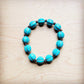 Turquoise beaded bracelet on a wood surface.