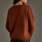 Woman in brown sweater and black pants.