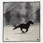 Black horse silhouette running on snowy ground.