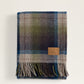 Plaid blanket with fringe and label.