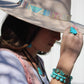 Woman in hat with turquoise jewelry.