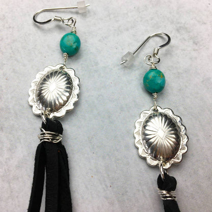 Silver earrings with turquoise beads and black tassels.
