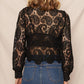 Woman wearing black lace top and denim skirt.