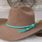Brown cowboy hat with turquoise braided band.