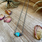 Turquoise beaded necklace with dried flowers on wood