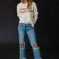 Woman in jeans and sweater.