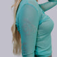 Woman wearing a turquoise mesh top with rhinestone design.