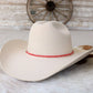 Cream-colored cowboy hat with red hatband.