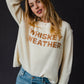 Woman in cream sweater and jeans.