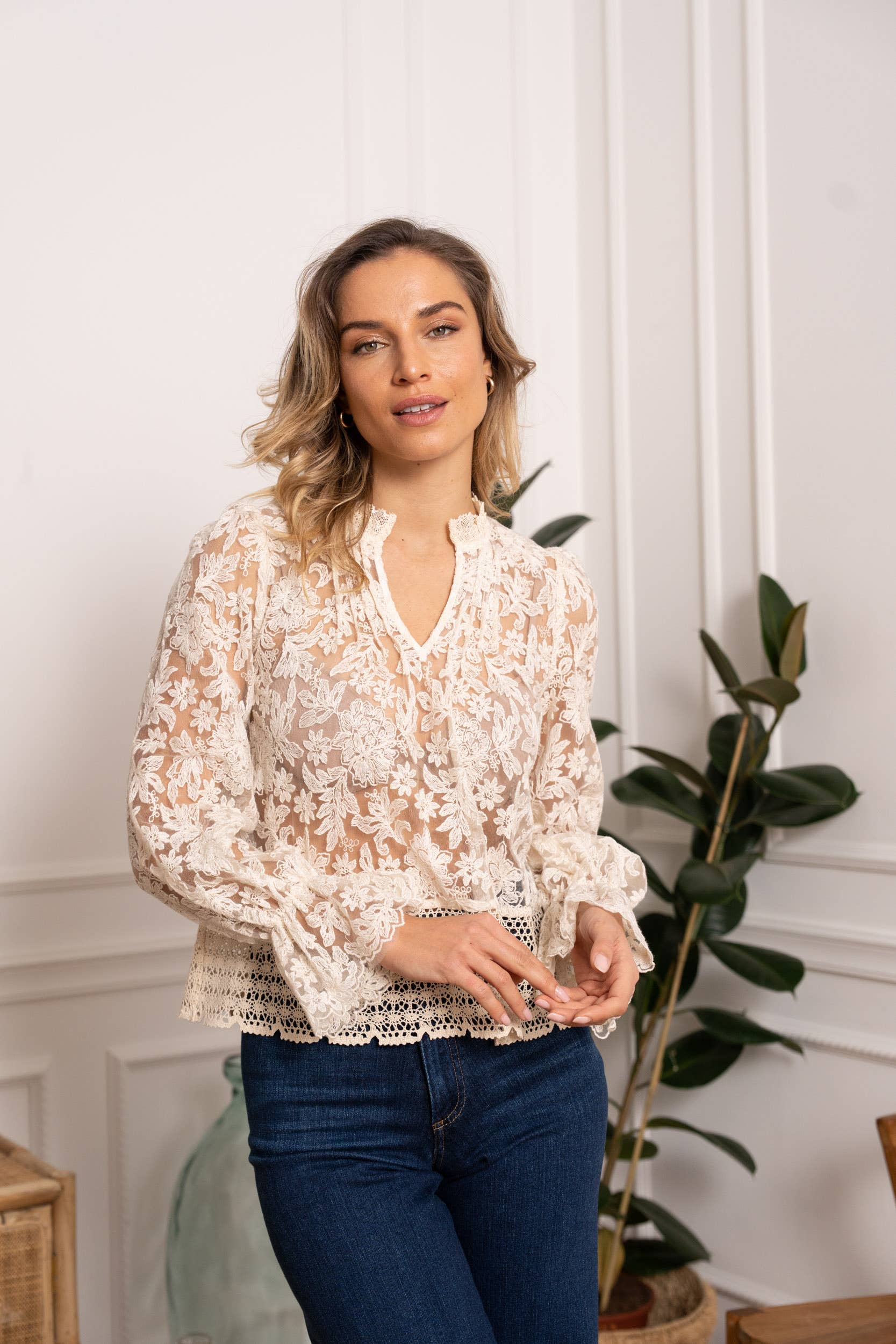 Woman in lace blouse and jeans.
