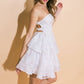 Woman in white strapless lace dress.