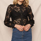 Woman in black lace top and denim skirt.