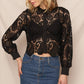 Woman in black lace top and denim skirt.