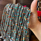 Hand holding beaded necklaces, A48298B4-0A00-48F3-A829-2FD54BD40A5B