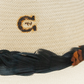 Straw hat detail with G logo and feathers