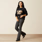 Woman in black sweatshirt and jeans, warm tones.