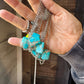 Turquoise stone necklaces held in hand