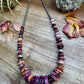 Purple beaded necklace on wood