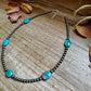 Turquoise bead necklace on wood surface