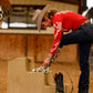 Cowgirl in red shirt and jeans adjusts boot, HMK_20532