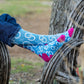 Person wearing blue patterned socks on wooden chair