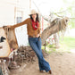 Cowgirl in red silk wild rag scarf, concho, & jeans