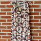 Patterned sleeveless dress hanging on a hanger.