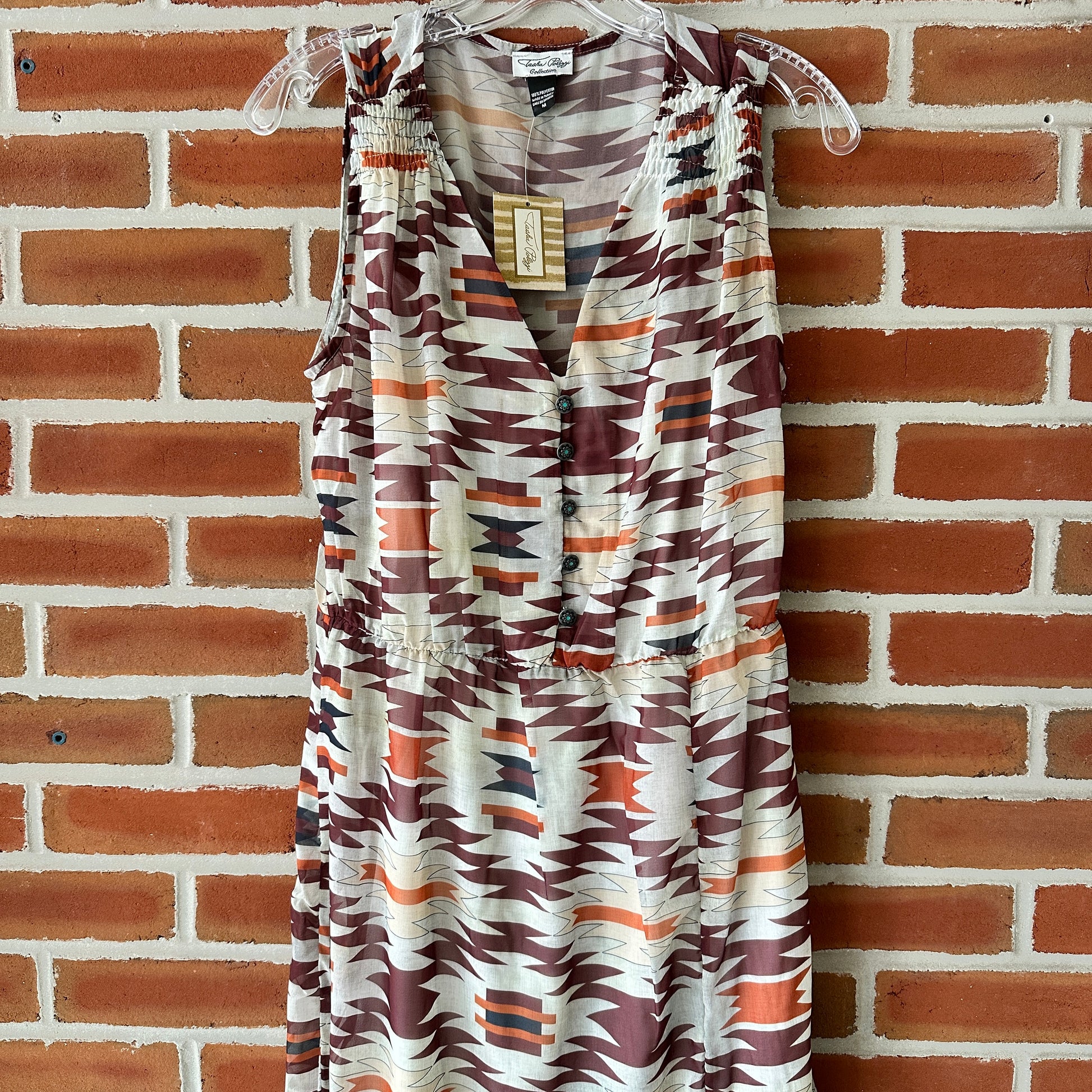 Patterned sleeveless dress hanging on a hanger.