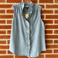 Blue denim sleeveless top with ruffle detail.