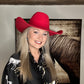 Woman in red cowboy hat and patterned shirt.