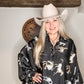 Woman wearing a cowboy hat and patterned shirt.