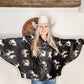 Woman in cowboy hat and horse-print shirt.