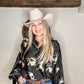 Woman in cowboy hat and patterned shirt.