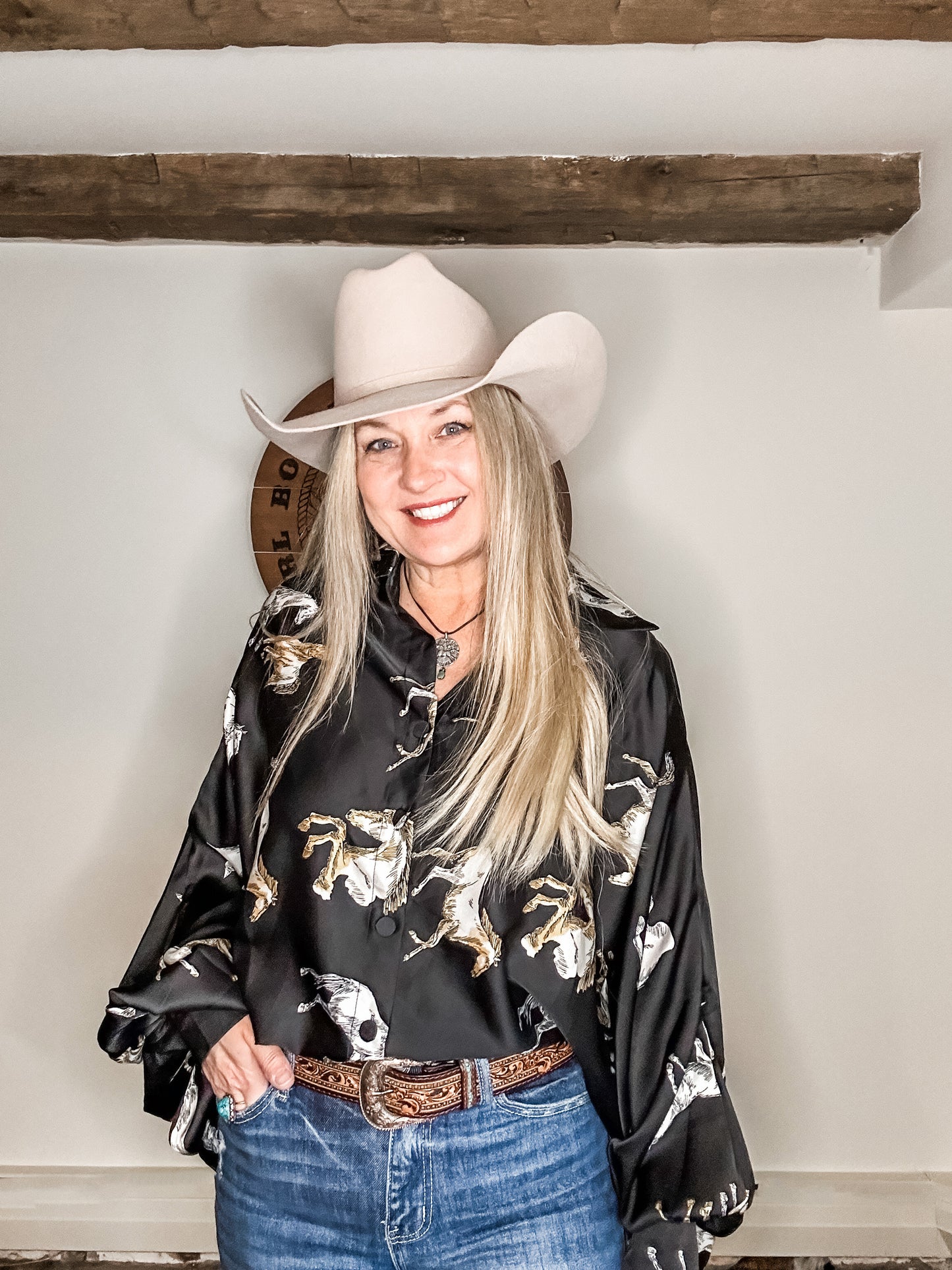 Woman in cowboy hat and patterned shirt.