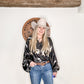 Woman in cowboy hat and patterned shirt.