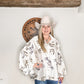 Woman in cowboy hat and horse-print shirt.