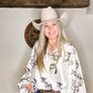 Woman in cowboy hat and patterned blouse.