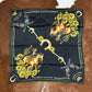 Black scarf with cowboy and sunflower design.