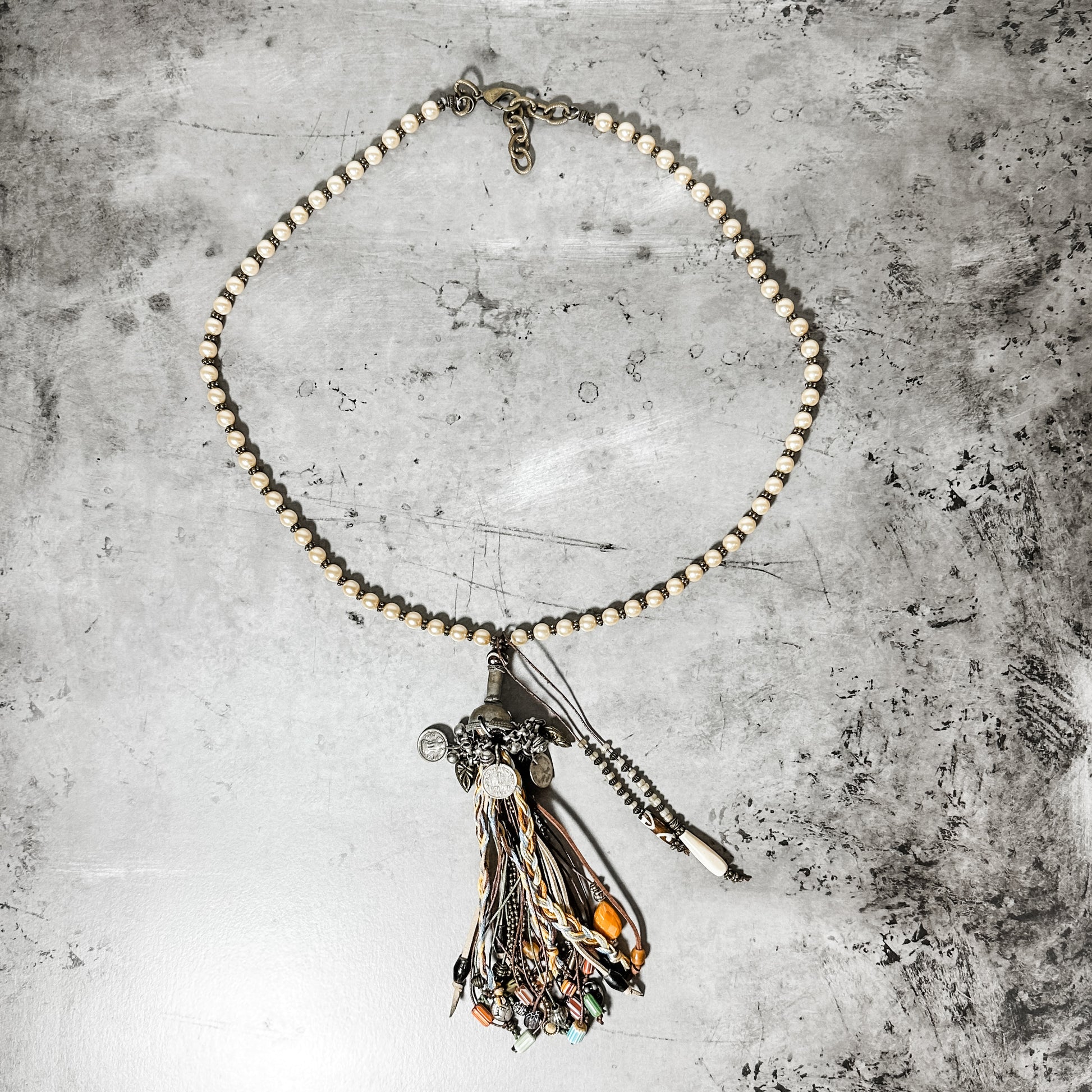 Beaded necklace with tassel pendant.