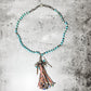Turquoise beaded necklace with tassel pendant.