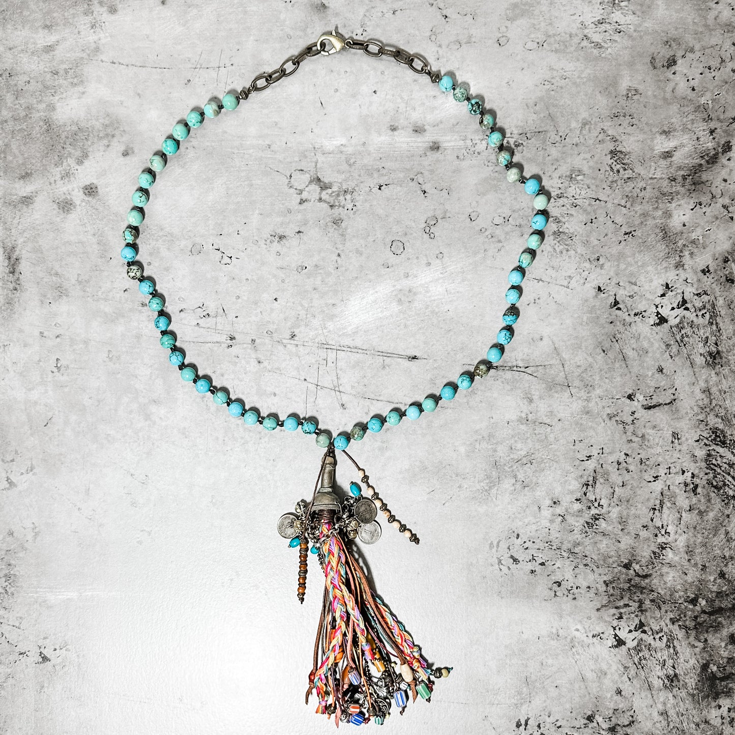 Turquoise beaded necklace with tassel pendant.