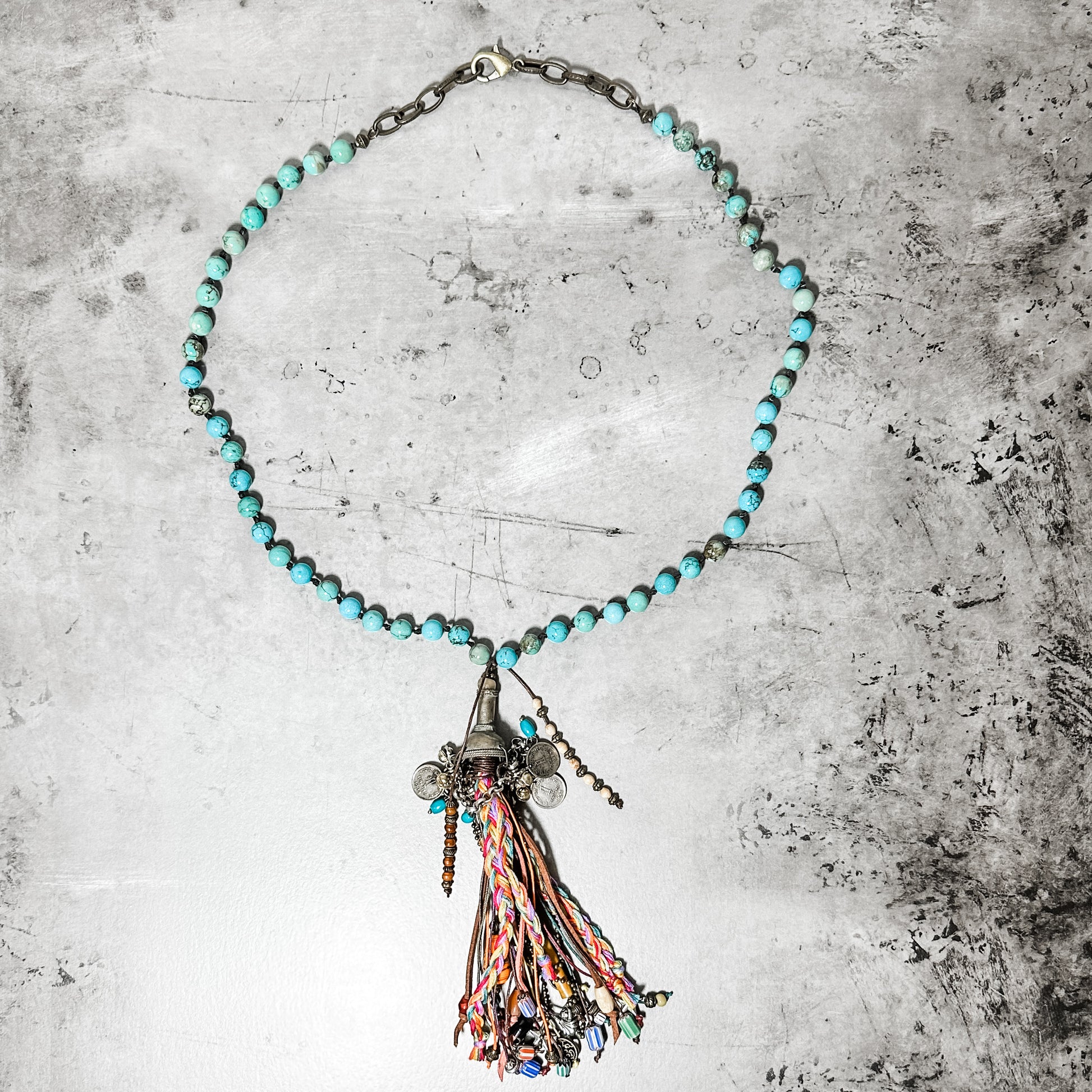 Turquoise beaded necklace with tassel pendant.