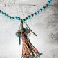 Turquoise bead necklace with a colorful tassel pendant.