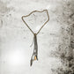 Necklace with dangling chains and feather.