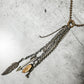 Necklace with charms, including a feather and arrow.