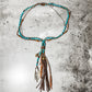 Necklace with turquoise beads and leather tassels.